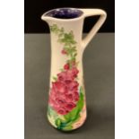 A Moorcroft Amber Wood jug, designed by Rachel Bishop, tune lined with foxgloves on an ivory ground,