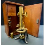 A late 19th/early 20th century lacquered brass and cast iron monocular microscope, rack-and-pinion