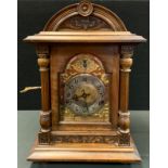 A late 19th century mahogany carved bracket clock, arched topped architectural case, gilt silvered