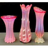 A cranberry and opaque Murano style art glass vase, the six petaled lipped body dribbled and