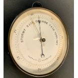 An early 20th century brass aneroid barometer, the silvered dial with engine turned centre, 17.5cm