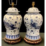 A pair of Chinese blue and white blaster vase table lamps, each relief decorated with phoenix and