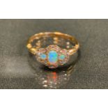 A diamond and opal cluster ring, with three oval opals flashing green, red and violet colour,