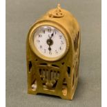 A German Art Nouveau brass travelling clock, pierced with tendrils and strap work, 9.5cm high, c.