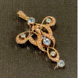 An Art Nouveau seed pearl and aquamarine pendant/brooch, the serpentine scrolling frame inset with