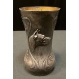 An early 20th century German pewter waisted cylindrical vase, embossed with sinuous scrolls, flowers