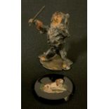 An early 20th century painted metal model, Spaniel conductor, standing holding a musical baton,