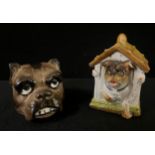 A late 19th century German porcelain novelty inkwell, as a Pug in a kennel, 8.5cm high, c.1910; a