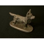 An early 20th century silvered car mascot, of a Rough Haired Terrier, oval base, 8cm wide, c.1930