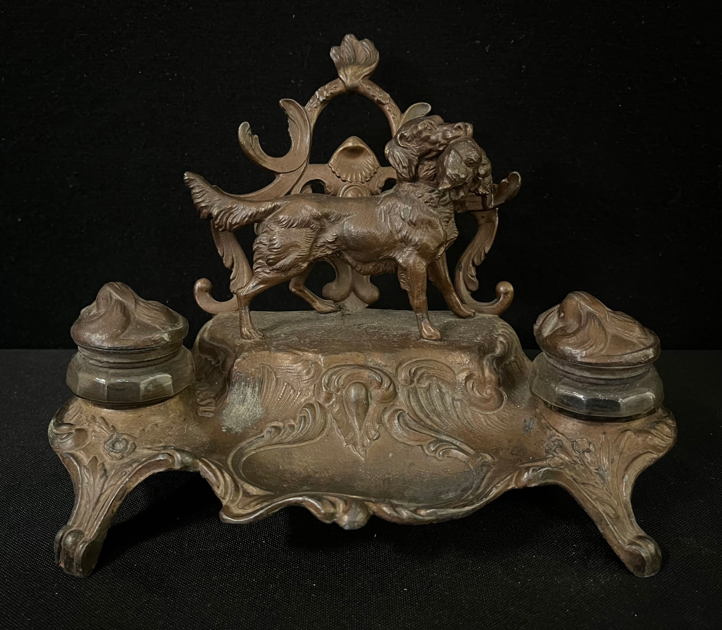 A late 19th century gilt spelter desk stand, with two wells and letter rack, surmounted with a