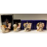 A set of four Royal Crown Derby candle holders, Goat, Gryphon, Lion and Bull, 9cm, printed marks,
