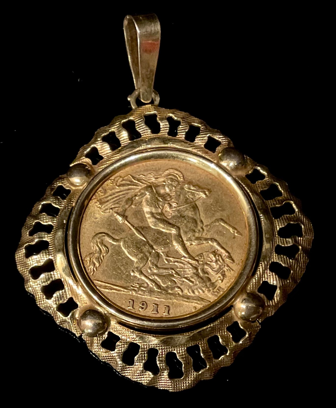 A George V gold half sovereign, 1911, mounted in 9ct gold as a pendant, 5.8g