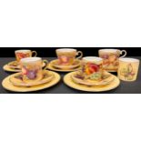 A set of three Aynsley Orchard Gold pattern coffee cans and saucers, printed with ripe fruits,