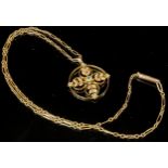 An Edwardian unmarked 9ct gold pendant and chain, the circular openwork pendant set with central