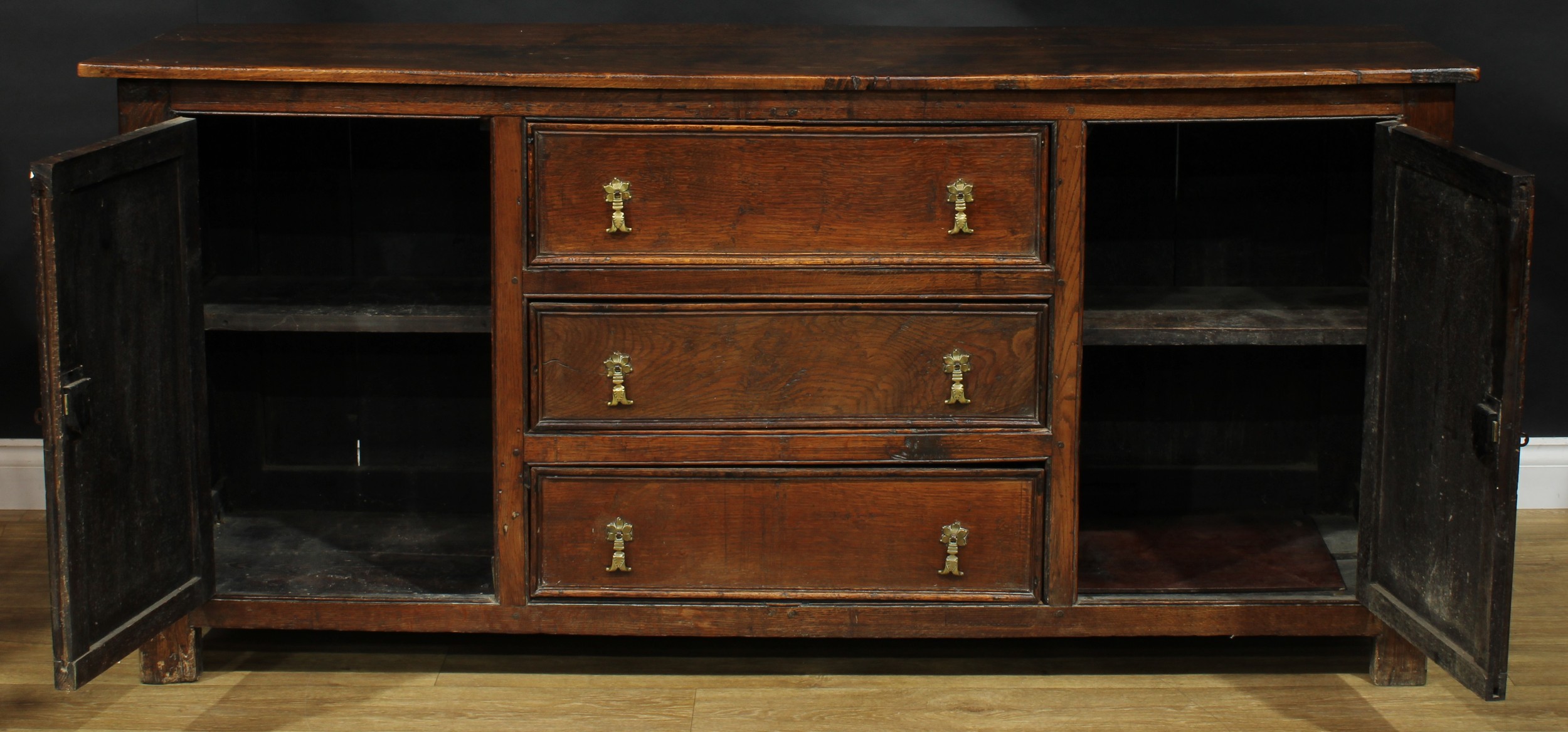 An oak low dresser, rectangular top above three drawers flanked by panel doors, each enclosing a - Image 2 of 4