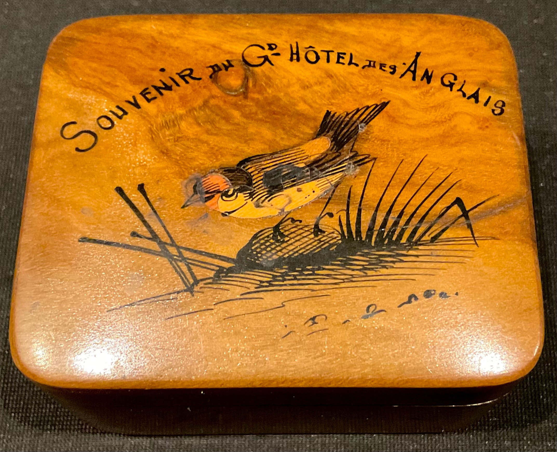 An early 20th century Mauchline type stamp box, the hinged cover painted with a gold finch, Souvenir