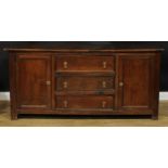 An oak low dresser, rectangular top above three drawers flanked by panel doors, each enclosing a