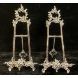 A pair of reproduction silver plated Rococo style easel picture stands, 51cm high