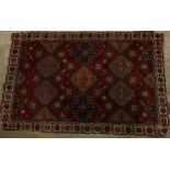 A Middle Eastern rectangular wool rug or carpet, the field with hooked medallions, geometric