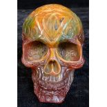 An amber coloured resin skull, cast with Celtic style scrolling decoration, 13cm high