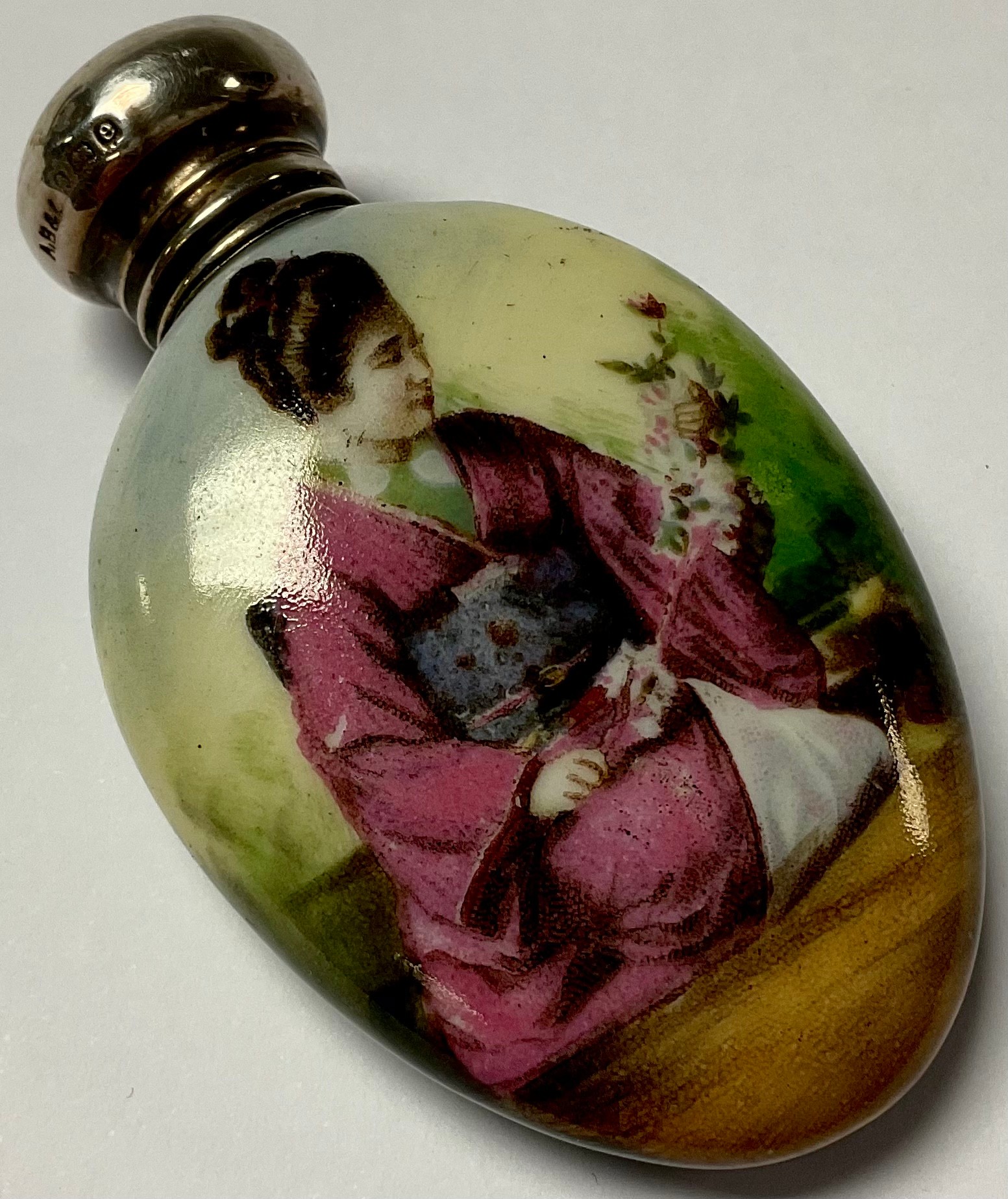 A porcelain scent bottle, Geisha holding flowers, hallmarked silver top