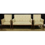 An Edwardian mahogany three-piece drawing room suite, comprising a sofa and a pair of armchairs, the