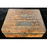 A 19th century crocodile skin bound dressing box, the hinged cover enclosing fitted trifold