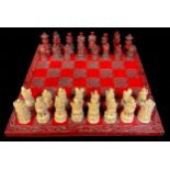 A chess set, the moulded resin pieces as Japanese warriors and peasants, moulded red lacquer style