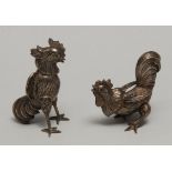 A pair of silver coloured metal models, of cockerels, the tallest 8cm high, apparently unmarked,