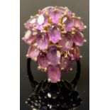 A gold coloured metal and amethyst dress ring, the 18 oval cut stones claw set
