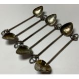 A set of six silver Arts & Crafts teaspoons, planished lily pad shaped bowls, leafy openwork