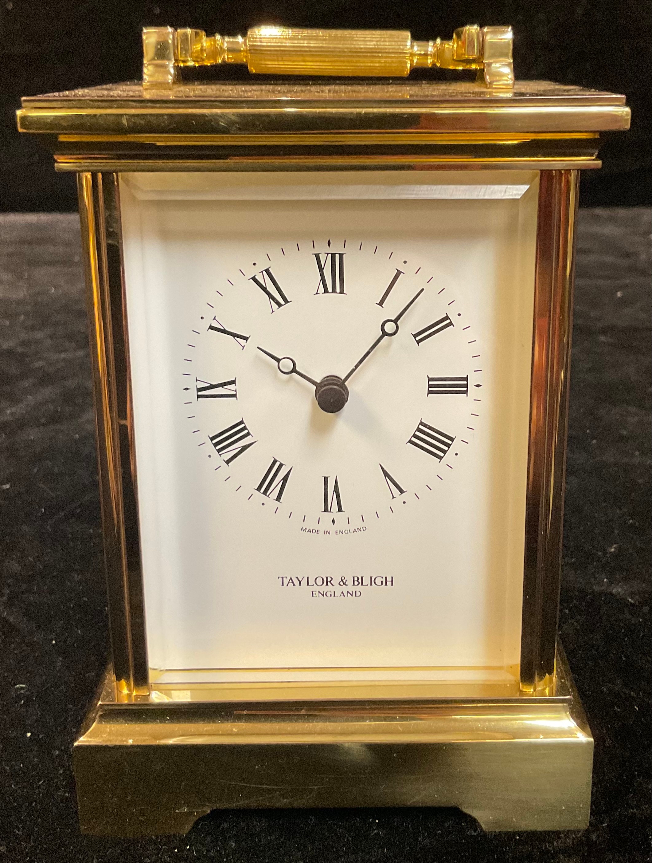 A Taylor & Bligh brass carriage timepiece, quartz movement, 17cm high over swing handle