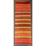 A Turkish woollen rug/runner, in bands of red, orange, ochre, black and green, 76cm wide, 208cm long