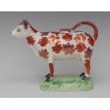 A Swansea cow creamer and cover, probably Cambrian Pottery, with pink-lustre and iron-red