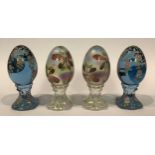 A pair of American Fenton glass hand painted opalescent eggs on stands, decorated with