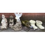 A collection of reconstituted stone garden ornaments including a gnome, a winged cherub, a