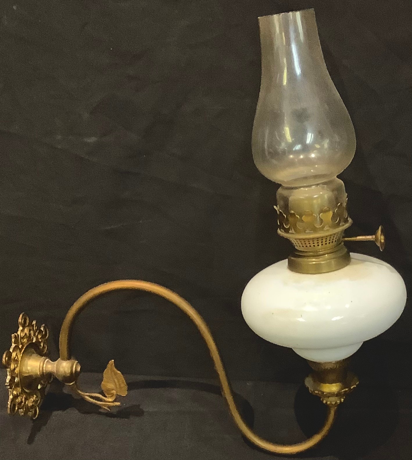 A Victorian brass and opaque glass wall mounted oil lamp, the globular reservoir supported on a '