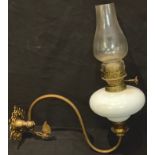 A Victorian brass and opaque glass wall mounted oil lamp, the globular reservoir supported on a '