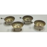 A set of four fluted salts as styalised chrysanthemum blossoms, ball and stem feet, the spoons