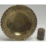 An Indonesian silver plated shaped circular dish, the edge embossed with animals amongst foliage