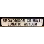 A decorative wooden sign, 'BROADMOOR CRIMINAL LUNATIC ASYLUM'