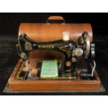 A Singer manual sewing machine, domed wooden carry case, with accessories
