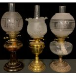 An early 20th century oil lamp, smoky glass font and pedestal base, Greek key frosted glass shade; a
