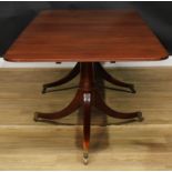 A Regency Revival mahogany dining table, rounded rectangular top with channelled edge and one