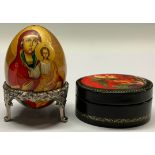 A Russian lacquer oval box and cover, decorated in polychrome with St Michael the Archangel Fighting