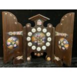 A decorative stained pine triptych wall clock, applied with enamel floral roundels, Roman