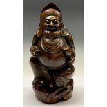 A Chinese bamboo figure, carved as a rotund Buddhist monk holding a fish, 28cm high