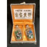 A pair of Chinese snuff bottles, reverse decorated with pandas, cased, each 7.5cm high