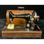 An early 20th century Singer hand cranked sewing machine, serial number EG04439, cased
