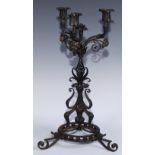 An Arts and Crafts wrought iron three light candelabra, worked in the Art Nouveau taste with flowers